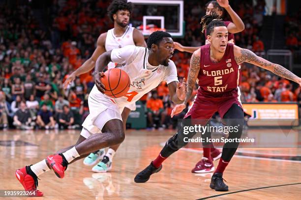 Miami guard Bensley Joseph drives to the basket while defended by FSU forward De'Ante Green in the first half as the Miami Hurricanes faced the...