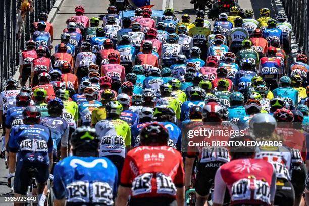 The peloton rides across a bridge during the fourth stage of the Tour Down Under cycling race in Adelaide on January 19, 2024. / -- IMAGE RESTRICTED...