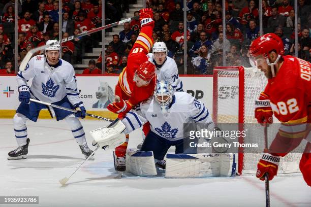 Jonathan Huberdeau of the Calgary Flames battles in front of the net against Martin Jones of the Toronto Maple Leafs at Scotiabank Saddledome on...