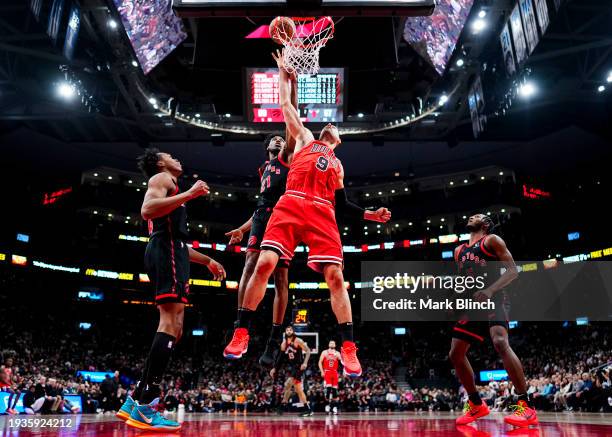 Nikola Vucevic of the Chicago Bulls battles for a rebound with Thaddeus Young of the Toronto Raptors during the first half of their basketball game...
