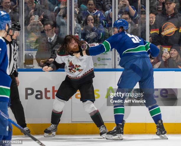 Nikita Zadorov of the Vancouver Canucks and Liam O'Brien of the Arizona Coyotes tussle during the first period of their NHL game at Rogers Arena on...