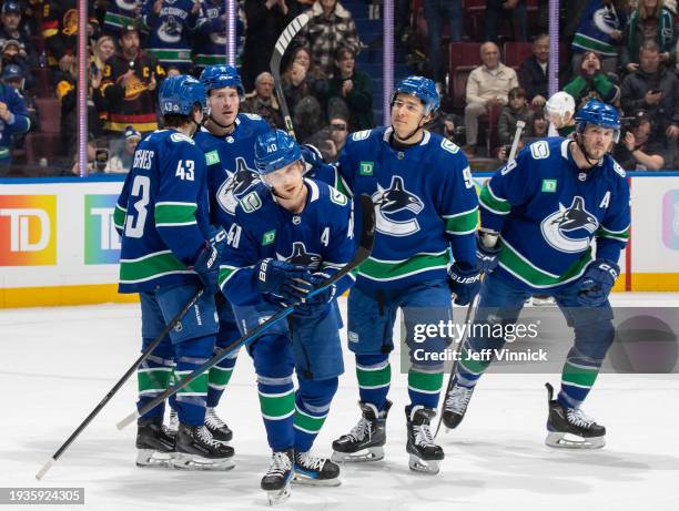 Elias Pettersson of the Vancouver Canucks skates back to the bench to celebrate his goal with teammates during the first period of their NHL game...