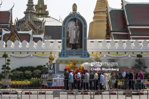 Visitors next to a portrait of the late Thai King Bhumibol Adulyadej in front of the Grand Palace in Bangkok, Thailand, on Wednesday, Jan. 17, 2024....