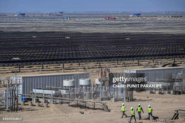 This photograph taken on January 12 shows employees at the Adani Group owned Khavda Renewable Energy Park in Khavda. Deep in the desert along the...