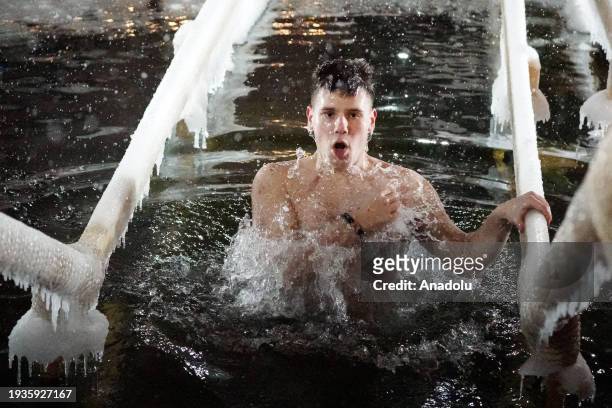 Followers of the Russian Orthodox Church plunge into freezing water through holes cut in the ice within the feast of the baptism of Jesus Christ in...