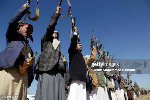 Houthi followers lift rifles and shout slogans against the U.S.-U.K. During a tribal gathering on January 14, 2024 on the outskirts of Sana'a, Yemen....