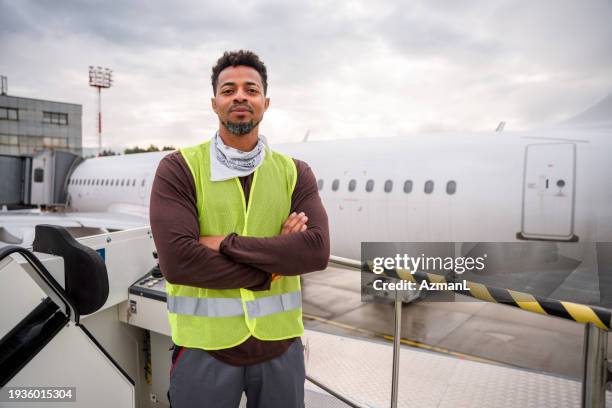 confident latin american male employee standing outdoors - airport ground crew uniform stock pictures, royalty-free photos & images