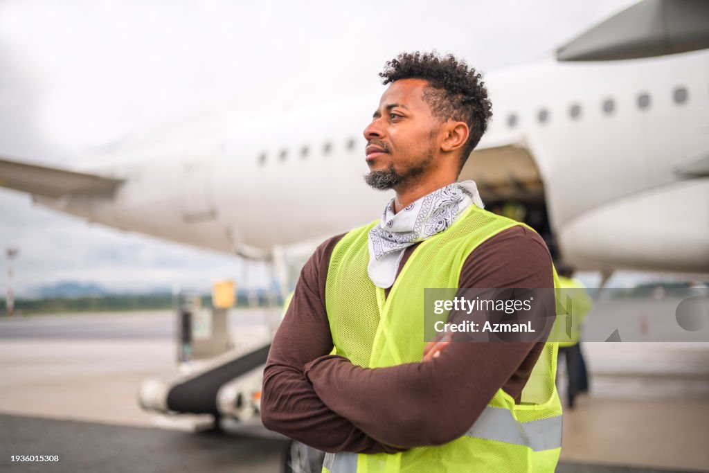 空港で人々のチームと一緒に働いているラテンアメリカの男性