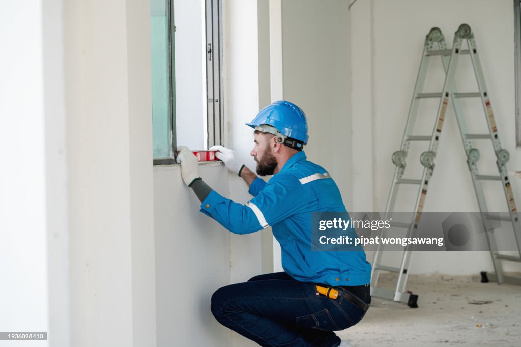 Window Frame Alignment The Construction Workers Are Using A Water Level To Measure The ...