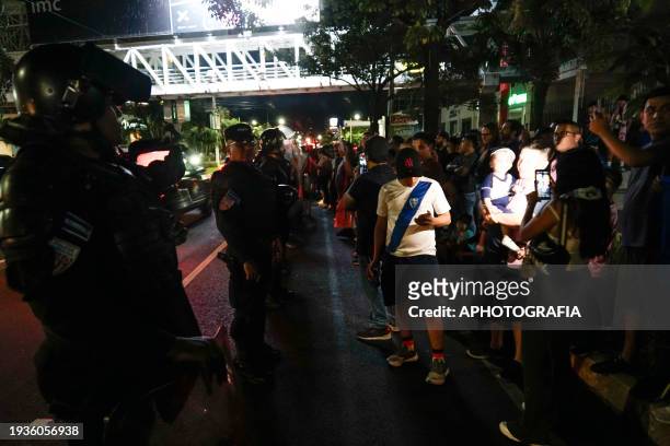 Police guard fans awaiting the arrival of Lionel Messi with the Miami FC team outside the Real Intercontinental Hotel on January 19, 2024 in San...