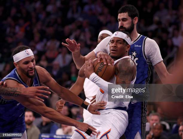 Miles McBride of the New York Knicks tries to keep the rebound as Jalen Suggs and Goga Bitadze of the Orlando Magic defend at Madison Square Garden...