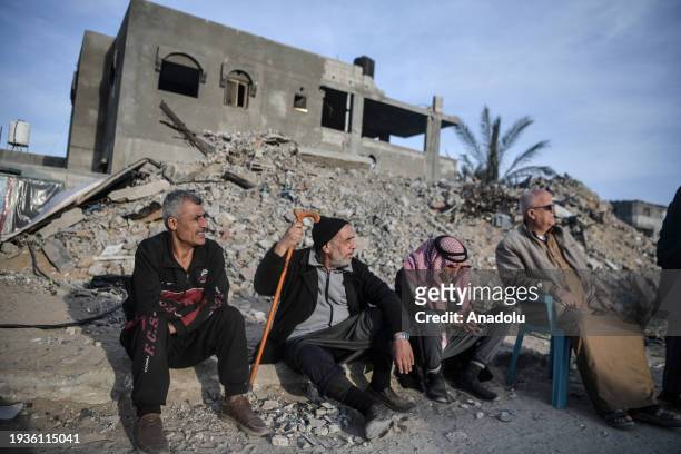 Palestinians are seen next to the rubble of a building destroyed by an Israeli attack while Israel's attacks continue on Gaza Strip as Palestinians...