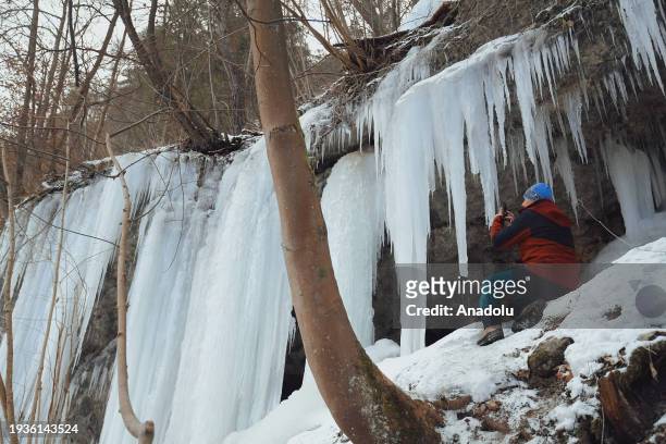 People pose for a photo while exploring the spectacular icefall Siklava Skala in Spisska Nova Ves district, Slovakia on January 16, 2024. The icefall...