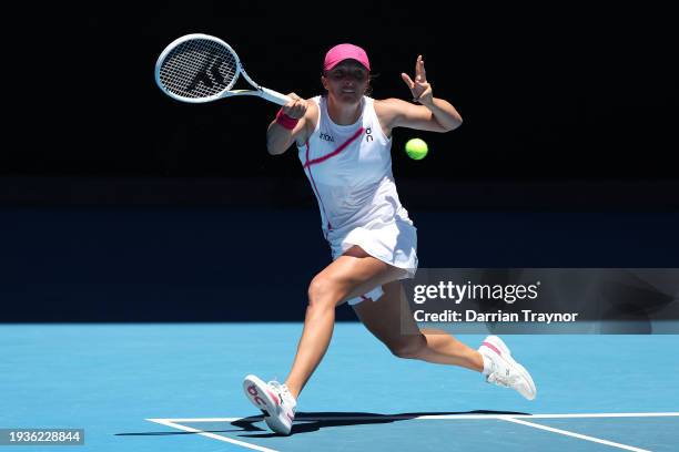 Iga Swiatek of Poland plays a forehand in their round one singles match against Sofia Kenin of the United States during the 2024 Australian Open at...