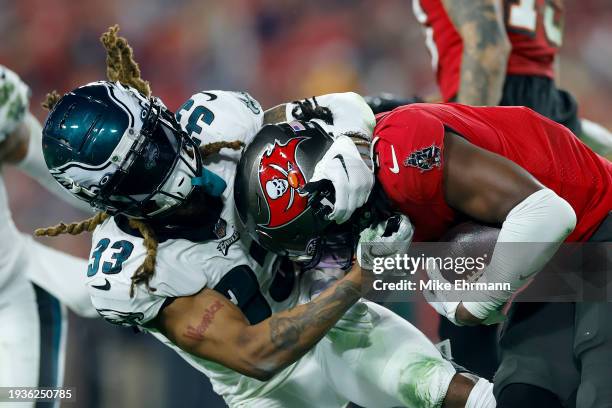 Bradley Roby of the Philadelphia Eagles tackles Rachaad White of the Tampa Bay Buccaneers during the second quarter in the NFC Wild Card Playoffs at...