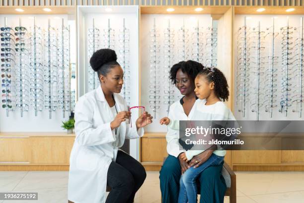 little girl trying on glasses with mom's supportive presence - kids fashion show stock pictures, royalty-free photos & images