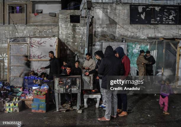 Palestinian Abdurrahman Shaat, who took refuge in the city of Rafah, cooks the pizzas on wood fire and sell prepared pizzas on the street while fuel...