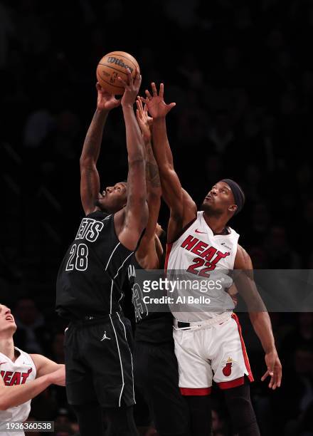 Dorian Finney-Smith of the Brooklyn Nets and Jimmy Butler of the Miami Heat battle for the ball during their game at Barclays Center on January 15,...