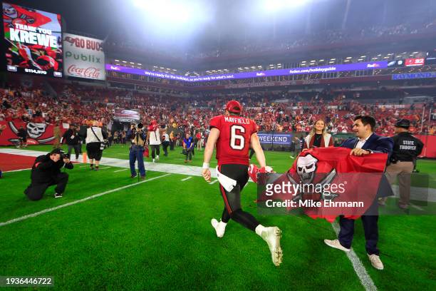 Baker Mayfield of the Tampa Bay Buccaneers runs off the field after defeating the Philadelphia Eagles in the NFC Wild Card Playoffs at Raymond James...