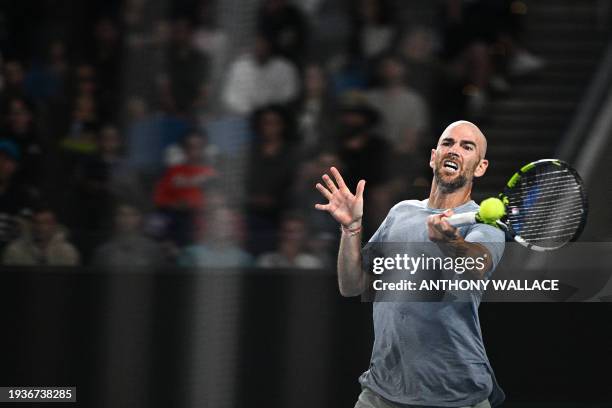 France's Adrian Mannarino hits a return against USA's Ben Shelton during their men's singles match on day six of the Australian Open tennis...