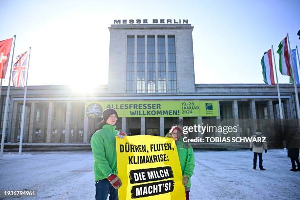Greenpeace activists hold a placard reading 'Droughts, floods, climate crisis' as they stage a demonstration on the opening day of the International...