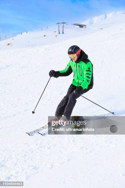 active lifestyle, vital senior  men snow skier skiing, enjoying on sunny ski resorts sellaronda, dolomiti superski. skiing carving at high speed against blue sky. - skiing and snowboarding stockfoto's en -beelden