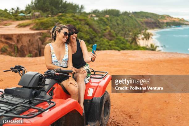femmes prenant un selfie sur un quad dans la nature - quadricycle photos et images de collection