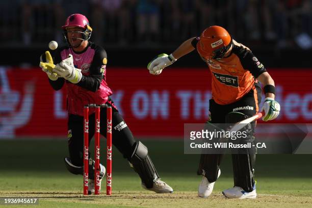 Josh Philippe of the Sixers takes a catch to dismiss Josh Inglis of the Scorchers during the BBL match between Perth Scorchers and Sydney Sixers at...