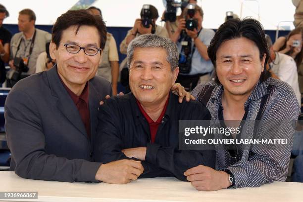 Korean director Im Kwon-Taek poses for photographers with actors Choi Min-Sik and Ahn Sung-Ki on a terrace of the palais des festivals during the...