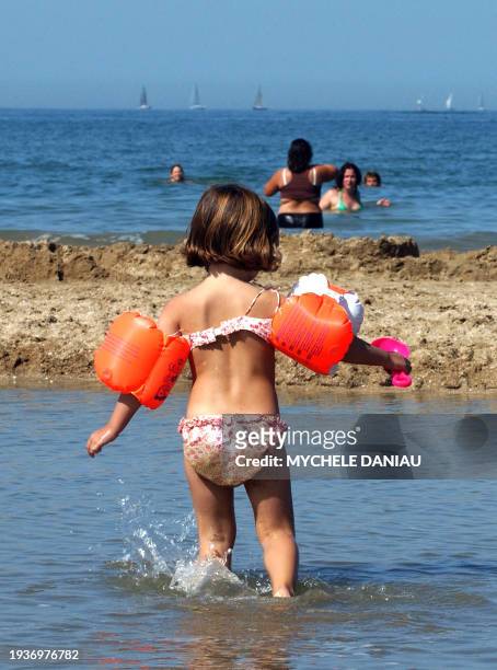 Child wears learn-to-swim arm floats, 10 September 2006 on the beach in Deauville. AFP PHOTO MYCHELE DANIAU