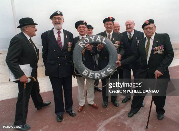 British veterans of the Royal Berkshire Regiment display 07 May 1994 a lifebelt belonging to their regiment which was found on the beach of Bernières...