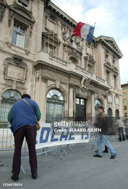 Des militants de la Confédération de défense des commerçants et artisans accrochent une banderole devant la mairie de Marseille, le 11 mars 2002,...
