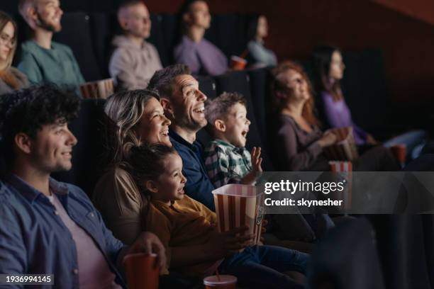 cheerful family watching a funny movie in theatre. - cinema premiere fotografías e imágenes de stock