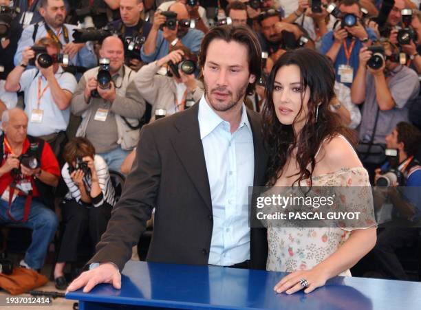Actor Keanu Reeves and Italian actress Monica Bellucci pose for photographers on a terrace of the Palais des festivals during the photocall for...
