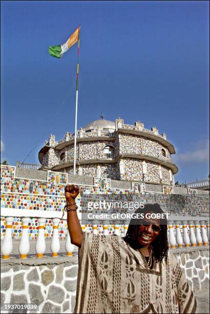 Le chanteur de reggae ivoirien Alpha Blondy lève le poing, le 11 mars 2002, devant sa demeure à Abidjan où il a annoncé lors d'un entretien avec la...