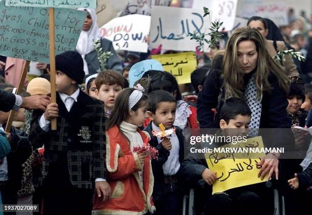 Syrian-born Egyptian actress Raghda adjusts a banner that reads "Yes To Peace, No To War" for a crippled Iraqi boy during a peaceful demonstration...