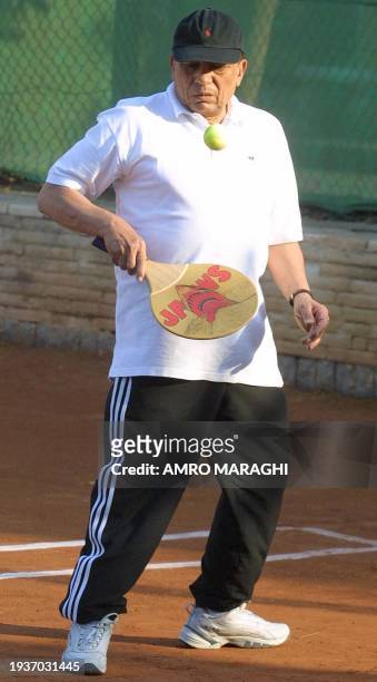 Egyptian comedian Adel Imam plays tennis with a wooden racket during a Ramadan tournament at Cairo's Shooting Club 13 November 2002. During the...