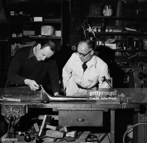 British racing driver Donald Campbell and his chief mechanic Leo Villa examine one of the rudders for Bluebird in the workshop of Campbell's cottage...