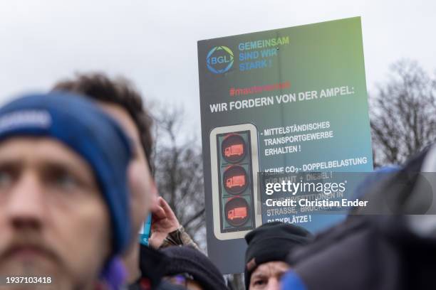 Protesting farmer holds a sign that reads to preserve the middle class transport industry, no double CO2 burden for tolls and diesel and more...