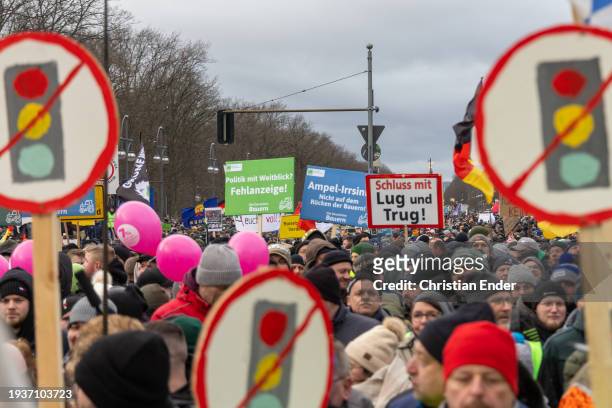 Protesting farmers hold signs with traffic lights crossed out to symbolize that the government should resign during a large-scale demonstration in...