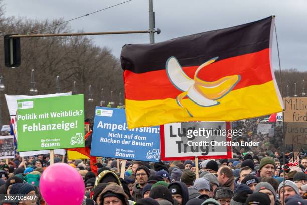 Protesting farmers wave a German flag during a large-scale demonstration in front of the Brandenburg Gate on January 15, 2024 in Berlin, Germany....