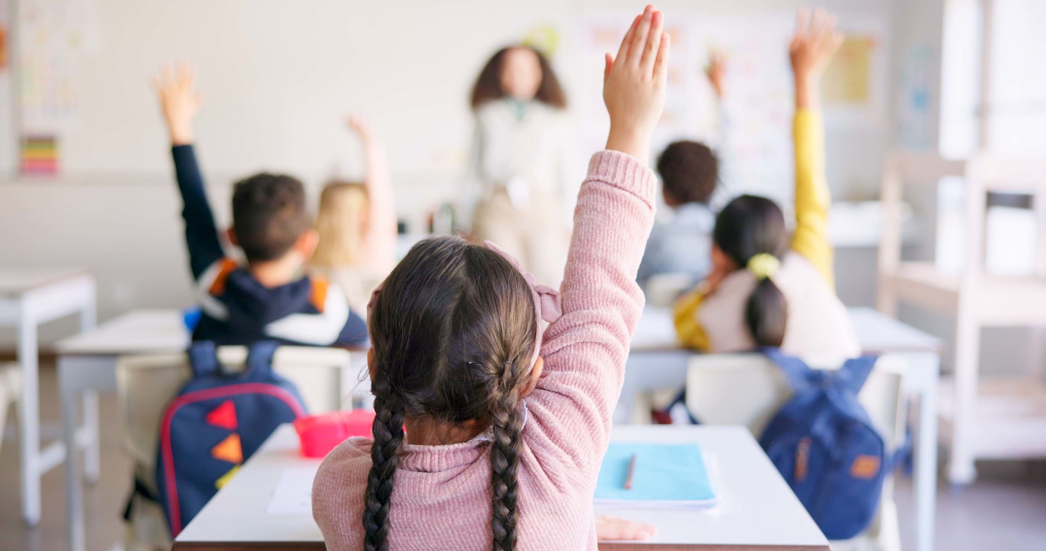 Education, raised hand and girl student in classroom with teacher for learning, discussion and knowledge. Help, studying and children students with questions for female educator or tutor at school. Education, raised hand and girl student in classroom with teacher for learning, discussion and knowledge. Help, studying and children students with questions for female educator or tutor at school.