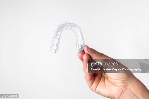 woman hand holding invisible dental aligner - cosmetic dentistry stock pictures, royalty-free photos & images