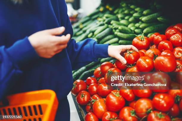 close up of woman's hand with red tomato at the market - tomate fotografías e imágenes de stock