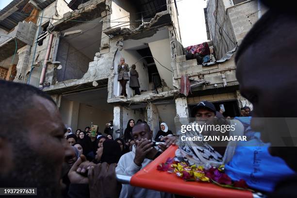 Mourners carry the body of one of the Palestinians, who were killed during a days-long Israeli raid, during their funeral in a refugee camp in...