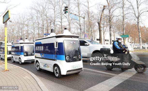 Unmanned patrol vehicles drive on a road during their road test on January 16, 2024 in Beijing, China. The first batch of unmanned patrol vehicles in...