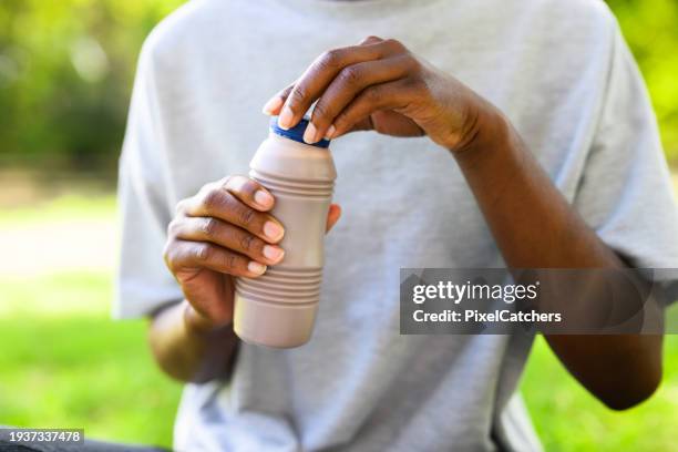 close up young woman opening chocolate milk bottle - chocolate milk stock pictures, royalty-free photos & images