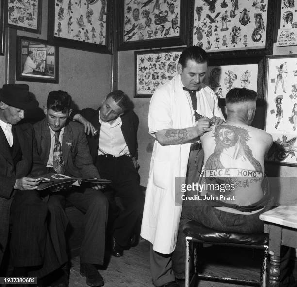 Tattooist Les Skuse, the founder of the Bristol Tattoo Club , tattoos an image of Jesus Christ, captioned 'Ecce homo' onto the back of a man at...