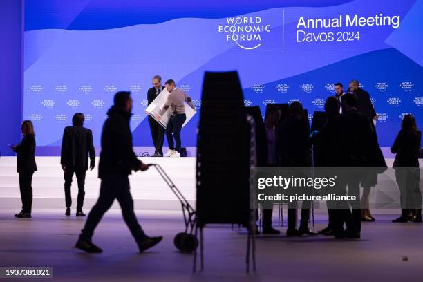 January 2024, Switzerland, Davos: Employees clear a conference hall after the closing event of the World Economic Forum . The annual meeting of the...