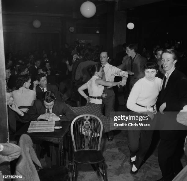 Some club patrons sit at their tables while others dance on the dancefloor of the Feldman Swing Club on Oxford Street, in the West End of London,...
